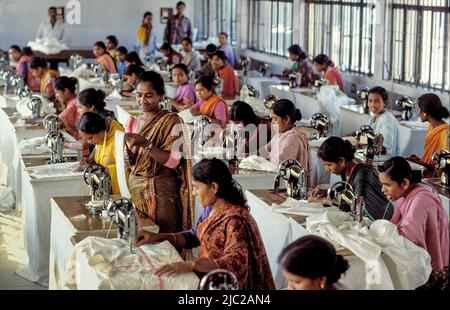 Bangladesch; Porträt einer Frau, die mit einer Nähmaschine arbeitet. Textilfabrik. Stockfoto