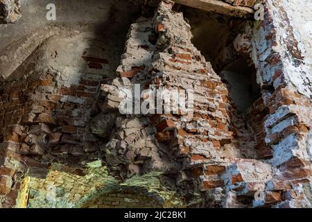 Zerstörte Mauer eines alten Gebäudes aus rotem Backstein gebaut. Stockfoto