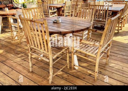 Leerer Holztisch und Stühle im Strandcafe Stockfoto