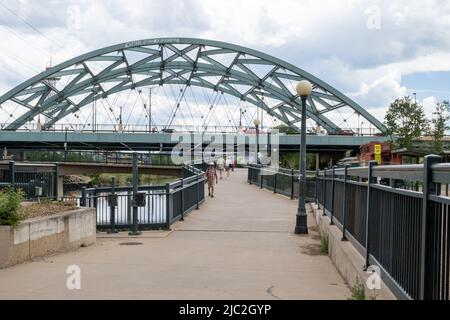 Denver, Colorado, 27. Mai 2022. Der öffentliche Spaziergang auf dem South Platte River Trail in der Nähe der Brücke auf dem Speer BLV an einem Tag mit blauem Himmel Stockfoto