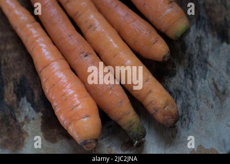 Gewaschene Karotten aus dem Garten auf Holzgesicht, natürliches Licht. Stockfoto