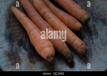 Gewaschene Karotten aus dem Garten auf Holzgesicht, natürliches Licht. Stockfoto