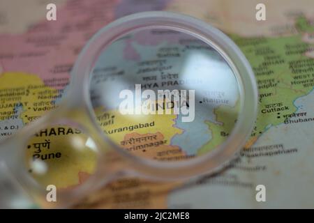 Der Name Indiens kann durch ein Vergrößerungsglas auf einer farbenfrohen physischen Karte Indiens gesehen werden Stockfoto