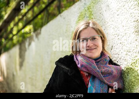 Attraktive 30-jährige Frau, posiert gegen eine raue Wand, Laeken, Brussel, Belgien Stockfoto