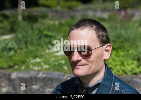Porträt eines 40-jährigen Mannes mit Sonnenbrille, natürlicher Hintergrund, Brüssel, Belgien Stockfoto
