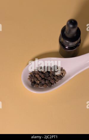 Braune Tropfflaschen mit Kräutern oder Gewürzen auf weißem Löffel, ohne Branding und mit korrekter Textfläche. Stockfoto