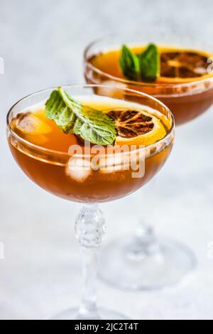Nahaufnahme von zwei Cocktails mit Orangenscheiben und frischer Minze Stockfoto