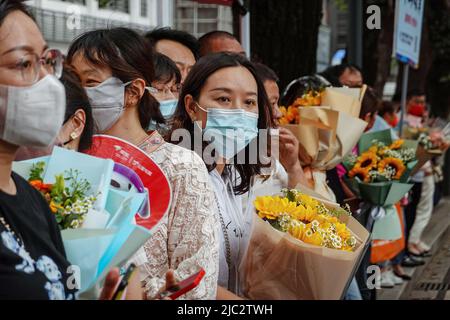 Changzhou, China. 09.. Juni 2022. Eine Mutter trägt Blumen, während sie auf ihr Kind wartet, das das letzte Fach der nationalen Hochschulaufnahme abgeschlossen hat. Bei der jährlichen Aufnahmeprüfung für das chinesische College, besser bekannt als „Gaokao“, haben sich in diesem Jahr Rekordkandidaten von 11,93 Millionen Kandidaten angemeldet. Abgesehen von einer Verschiebung in Shanghai aufgrund von COVID-19 startete die Prüfung am 7.. Juni 2022 landesweit. (Foto von Sheldon Cooper/SOPA Images/Sipa USA) Quelle: SIPA USA/Alamy Live News Stockfoto