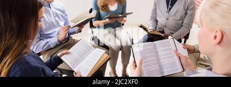 Gruppe von Menschen sitzen auf Stuhl im Kreis lesen Bibeln Stockfoto