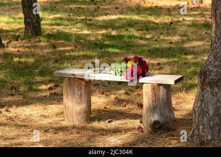 Blumenstrauß auf einer Bank im Park in Vintage-Style-Stimmung Stockfoto