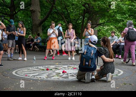 Touristen, die Fotos am John Lennon Memorial machen oder Imagine Mosaic im Central Park, New York City, Vereinigte Staaten von Amerika Stockfoto