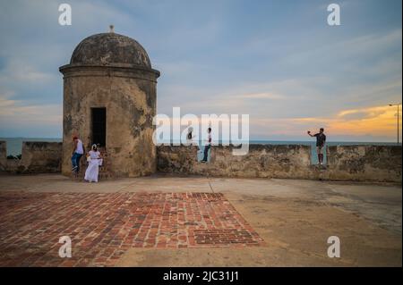 Besucher genießen den Sonnenuntergang von oben auf den Mauern der Altstadt von Cartagena, Kolumbien Stockfoto