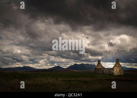 Ein düsteres, sommerliches HDR-Landschaftsbild eines ruinierten Solitary Moine House mit Ben Loyal im Hintergrund, Sutherland, Schottland. 31 Mai 2022 Stockfoto