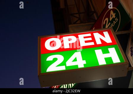 Nahaufnahme des Ausschildes für 24 Stunden geöffnet in der Dämmerung - Stockfoto Stockfoto