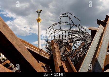 Kiew, Ukraine. 09.. Juni 2022. Das Unabhängigkeitsdenkmal auf dem Maidan-Platz ist am 9. Juni 2022 durch Metallstraßenbarrikaden und Stacheldraht in der Altstadt von Kiew, Ukraine, zu sehen. Als die Russische Föderation vor 3 und einem halben Monat in die Ukraine einmarschierte, dauern die heftigen Kämpfe im Osten des Landes an. Die Hauptstadt Kiew bleibt in relativer Sicherheit, obwohl in der ganzen Stadt Erinnerungen an den Krieg wie schützende Sandsäcke, Straßensperren, nationale und Anti-Kriegs-Symbole zu sehen sind. (Foto von Dominika Zarzycka/Sipa USA) Quelle: SIPA USA/Alamy Live News Stockfoto