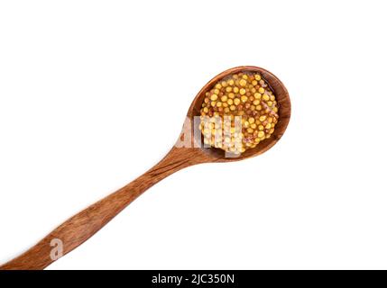 Draufsicht auf Holzlöffel mit Dijon-Senf auf weißem Hintergrund. Senfsauce mit weißen und schwarzen Senfkörnern. Speicherplatz kopieren. Stockfoto