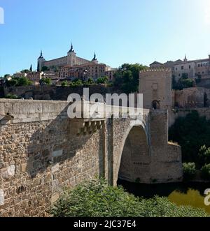Die Alcantara-Brücke, mit dem Alcazar von Toledo im Hintergrund. Spanien. Stockfoto