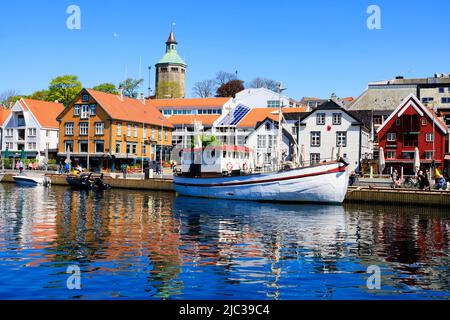 Traditionelles norwegisches Fischerboot, das im Hafen von Stavanger festgemacht ist. Alte Lagerhäuser am Kai sind jetzt trendige Restaurants, Bars und Cafés., Norwegen. In der BA Stockfoto