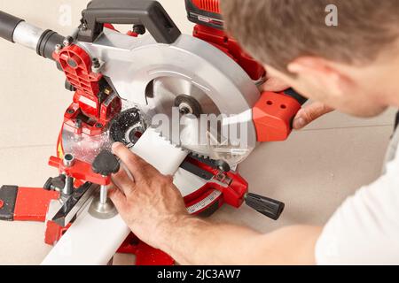 Schneiden von Sockelleisten mit einem professionellen Schneidwerkzeug Stockfoto
