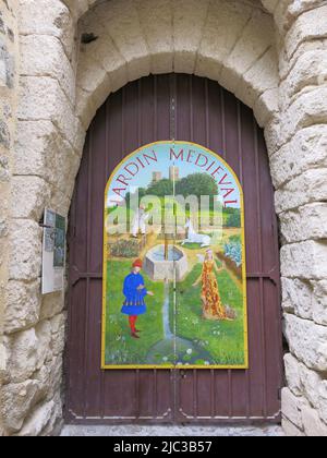 Eine gemalte Szene eines formalen Gartens im Mittelalter auf dem Holzeingang am Eingang zum 'Jardin Medieval' in Uzes. Stockfoto