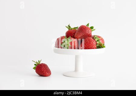 Frische Erdbeeren in weißem Teller auf weißem Hintergrund Stockfoto