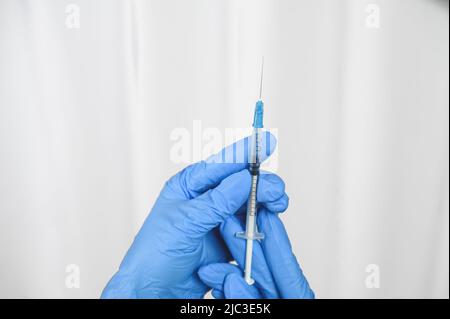 Krankenschwesternhänden halten eine Spritze mit einem Impfstoff für Virusinfektionen. Das Konzept der Impfung. Stockfoto