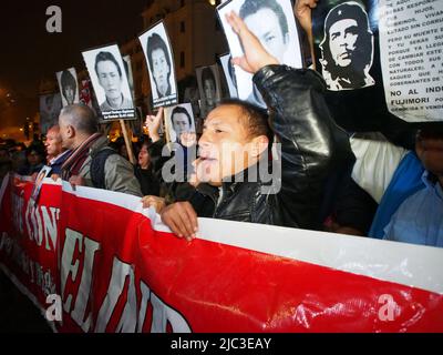 Hunderte von Menschen, die Porträts ihrer vermissten Verwandten trugen, gingen auf die Straßen von Lima, um gegen eine mögliche Begnadigung des ehemaligen Präsidenten Alberto Fujimori zu protestieren, der seine Strafe für Verbrechen gegen die Menschenrechte absetzt. Die derzeitige peruanische Regierung spekuliert mit der Möglichkeit der Begnadigung, als Instrument der Verhandlungen mit der Fujimoristischen parlamentarischen Mehrheit. Stockfoto