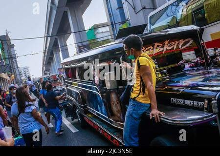 Quezon, Philippinen. 9.. Juni 2022. Der Jeepney-Disponent sitzt an der Haube eines sich bewegenden Jeepneys, während er Passagiere anruft. Dieselkraftstoff, der am häufigsten für Jeepneys (PUJ), einen Passagierjeep, verwendet wird, stieg auf fast 7 Pesos und erreichte 75 bis 87 philippinische Peso (1,45 bis 1,64USD) pro Liter, was zu einem Nettoanstieg auf 36 Pesos führte. Einige Jeepney-Fahrer halten ihre Fahrten aufgrund der fortandauernden Ölpreiserhöhungen immer noch an. (Bild: © Ryan Eduard Benaid/SOPA Images via ZUMA Press Wire) Stockfoto