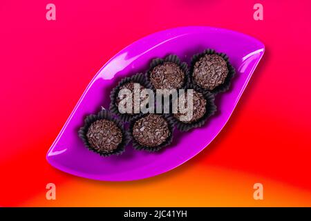 Brigadeiro in pinker Schale auf buntem, gradienten Hintergrund. Stockfoto