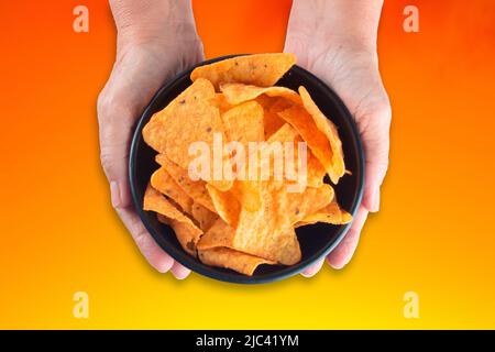 Hand halten Schüssel mit knackigen Käsechips. Stockfoto