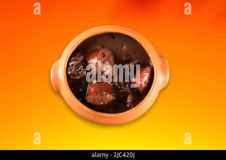 Feijoada in Keramik Topf mit Farbverlauf Hintergrund. Stockfoto
