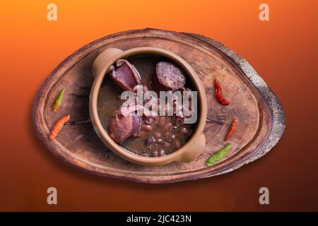 Feijoada in Keramik Topf mit Farbverlauf Hintergrund. Stockfoto