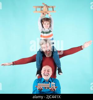 Männer Generation: Großvater Vater und Enkel spielen mit Spielzeug Flugzeug. Junge träumt davon, Pilot zu werden. Journey Reise Reisekonzept. Isoliert Stockfoto