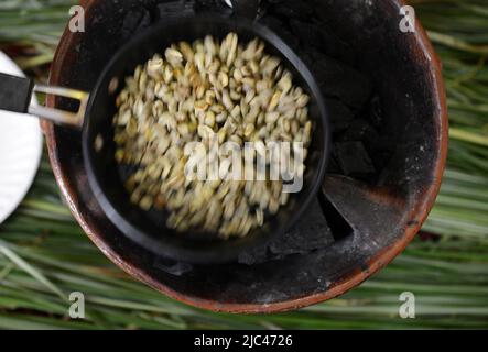 Rösten von Kaffeebohnen in einer traditionellen äthiopischen Kaffeeremonie. Stockfoto