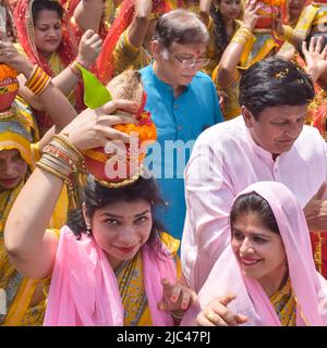 Neu Delhi, Indien April 03 2022 - Frauen mit Kalash am Kopf während des Jagannath-Tempels Mangal Kalash Yatra tragen indische Hindu-Anhänger irdische Töpfe Conta Stockfoto