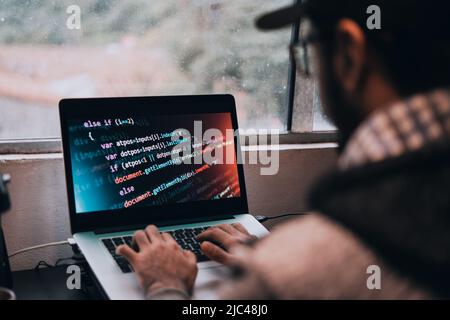 Junger Mann, der zu Hause von seinem Computer aus studiert Stockfoto