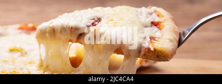 Nahaufnahme einer köstlichen Cheesy Pizza auf hölzernen Tisch Stockfoto