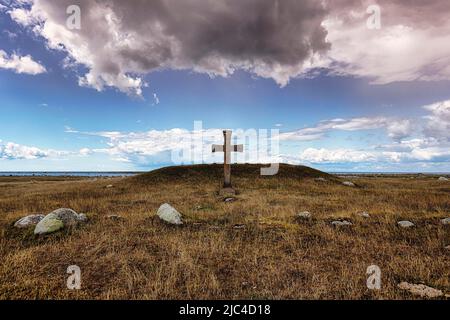 Steinkreuz in einer kargen Wiese, dramatischer Wolkenhimmel, Kyrkhamn, Südoland, Oeland, Kalmar laen, Schweden Stockfoto