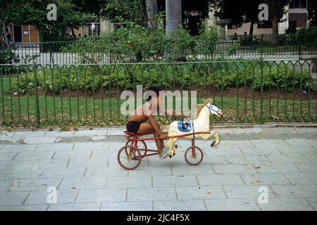 Kubanischer Junge auf einer Pferdekutsche mit einem Holzpferd, Havanna, Kuba, Karibik Stockfoto