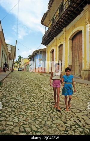 Zwei junge Mädchen, die auf einer Gasse mit Kopfsteinpflaster spazieren, Trinidad, UNESCO-Weltkulturerbe, Kuba, Karibik Stockfoto