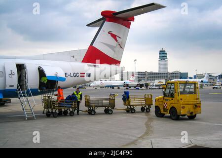 Austrian Arrows Airline Entladen von Gepäck auf Asphalt, Flughafen Wien, Österreich Stockfoto