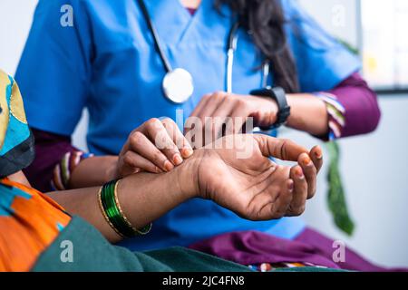 Nahaufnahme des Arztes, der den Puls zählt, indem er die Hand des kranken Patienten hält - Konzept der Gesundheitskontrolle, medizinische Beratung und Diagnose Stockfoto