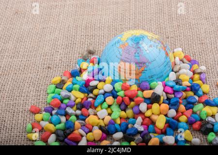 Modell Kugel platziert inmitten von bunten Steinchen Stockfoto