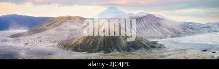 Ansicht von oben, atemberaubenden Panoramablick auf den Berg, Mount Batok Bromo und den Berg Semeru in der Ferne leuchtet bei Sonnenaufgang. Stockfoto