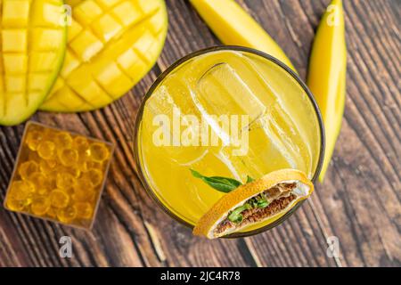 Mangolemonade mit Bubble Tea auf dunklem Holzhintergrund Stockfoto