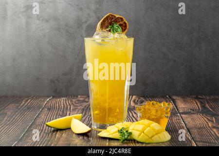 Mangolemonade mit Bubble Tea auf dunklem Holzhintergrund Stockfoto