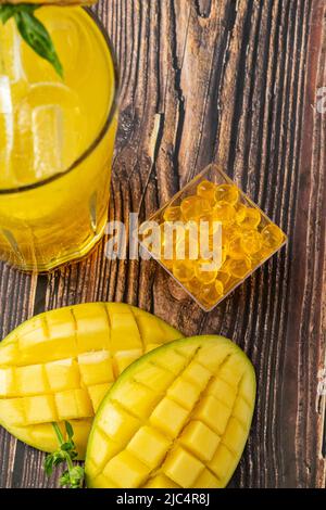 Mangolemonade mit Bubble Tea auf dunklem Holzhintergrund Stockfoto