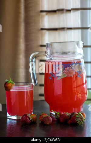 Frischer Erdbeersaft in einem Glas am Fenster. Stockfoto
