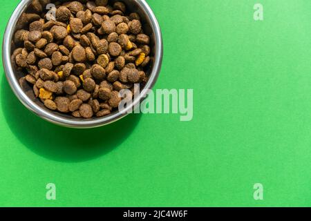 Kibble in PET-Schale auf dem grünen Hintergrund Stockfoto