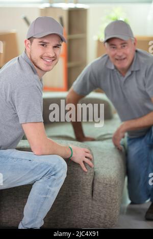 Männer liefern ein neues Sofa auf ein Grundstück Stockfoto